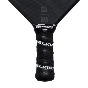 Close-up of a black pickleball paddle grip with white Selkirk branding.