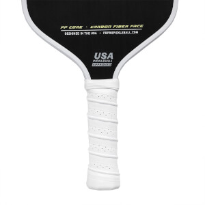 Top-down view of a black pickleball paddle with white grip, USA PICKLEBALL APPROVED text, and CARBON FIBER FACE details.