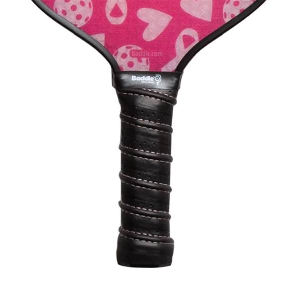 Top-down view of a pink pickleball paddle with a heart pattern and black grip.
