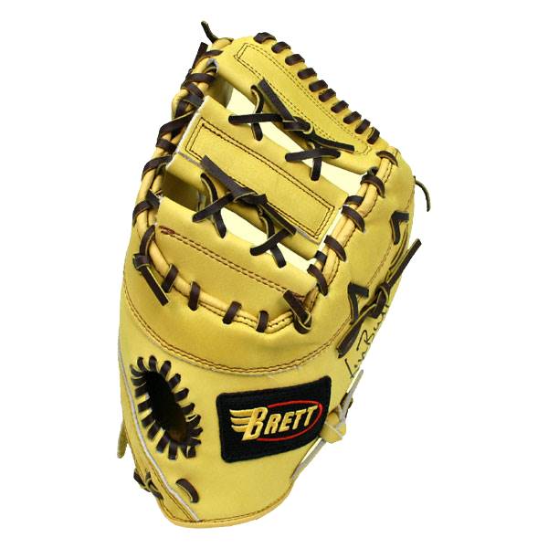Top-down view of a tan first base mitt with dark brown lacing and a black Brett logo.