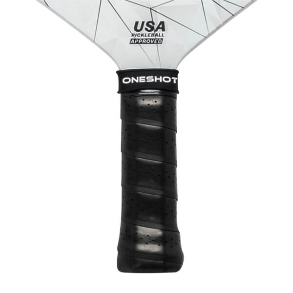 Close-up of a black pickleball paddle grip with ONESHOT branding and USA PICKLEBALL APPROVED on the head.