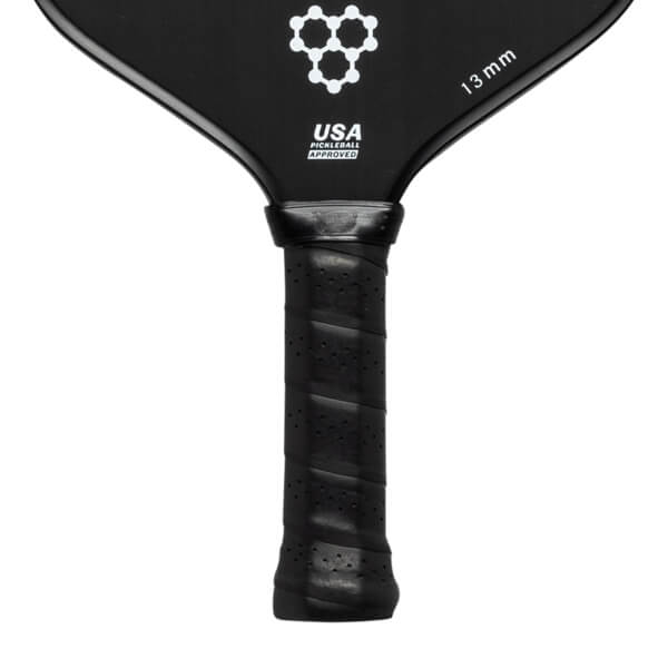 Close-up of a black pickleball paddle with a perforated grip, USA PICKLEBALL APPROVED text, and 13 mm marking.