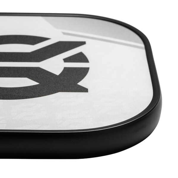 Corner view of a white pickleball paddle with a black border and a large black graphic.