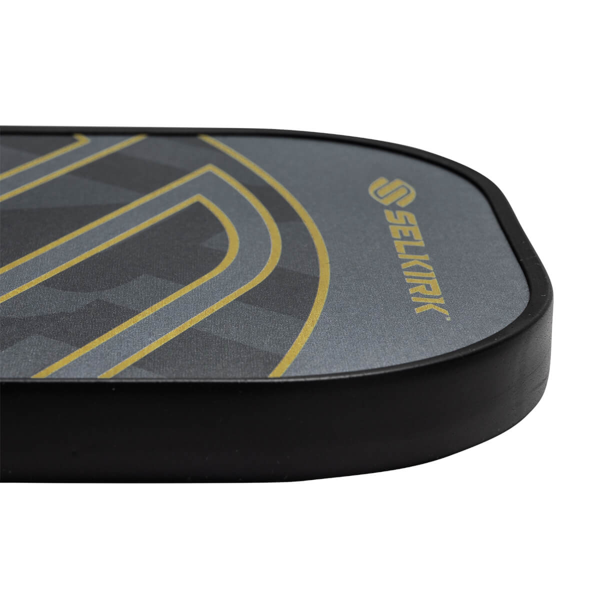 Corner view of a gray pickleball paddle with a black edge and gold Selkirk logo.