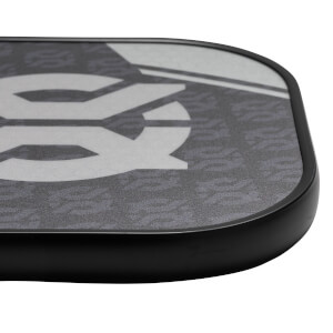 Corner view of a gray pickleball paddle with a large white graphic and black edge.
