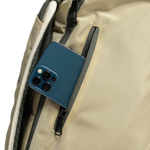 Close-up view of a tan backpack with a dark blue smartphone partially tucked into a vertical side zippered pocket.