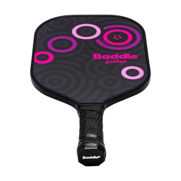 Front view of a black Baddle Junior pickleball paddle with pink circles and a textured grip.