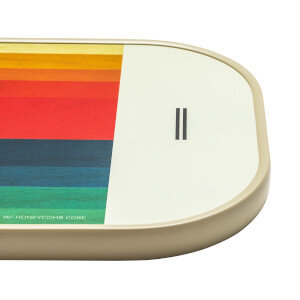Corner view of a cream pickleball paddle with a rainbow stripe design and black double bar logo.