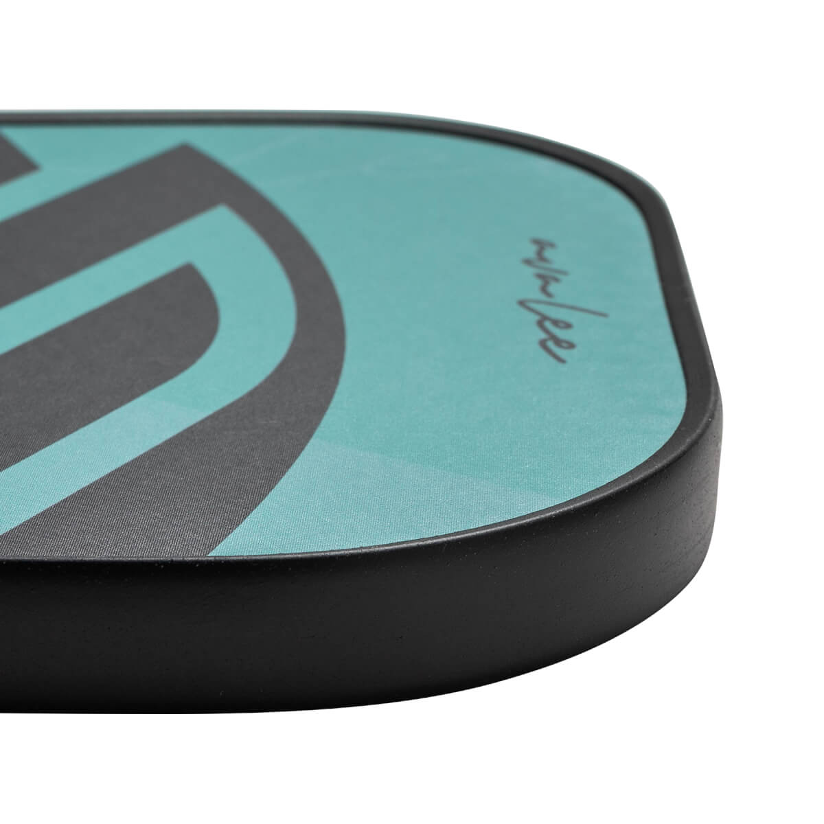 Corner view of a teal and black pickleball paddle with a curved graphic and handwritten signature.