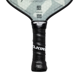 Close-up of a black pickleball paddle grip with a textured surface and SELKIRK branding.