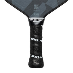 Close-up of a black pickleball paddle grip with SELK branding and a textured pattern.