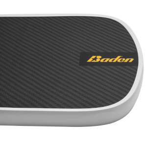 Corner view of a black pickleball paddle with a carbon fiber surface and yellow Baden logo.