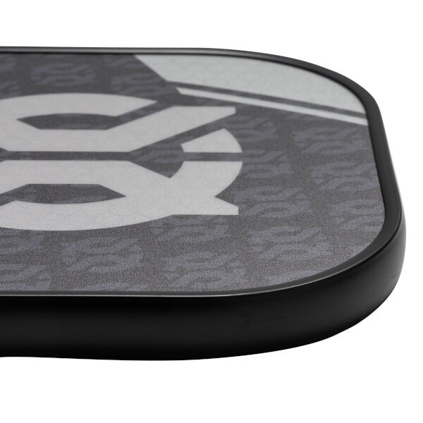 Corner view of a gray pickleball paddle with a large white graphic and black edge.