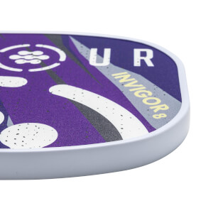 Corner view of a purple pickleball paddle with white text UR INVIGOR8 and speckled white and grey accents.
