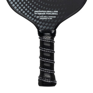 Close-up of a black pickleball paddle grip with white stitching and text OMEGAPICKLEBALL.COM BY ENGAGE PICKLEBALL.