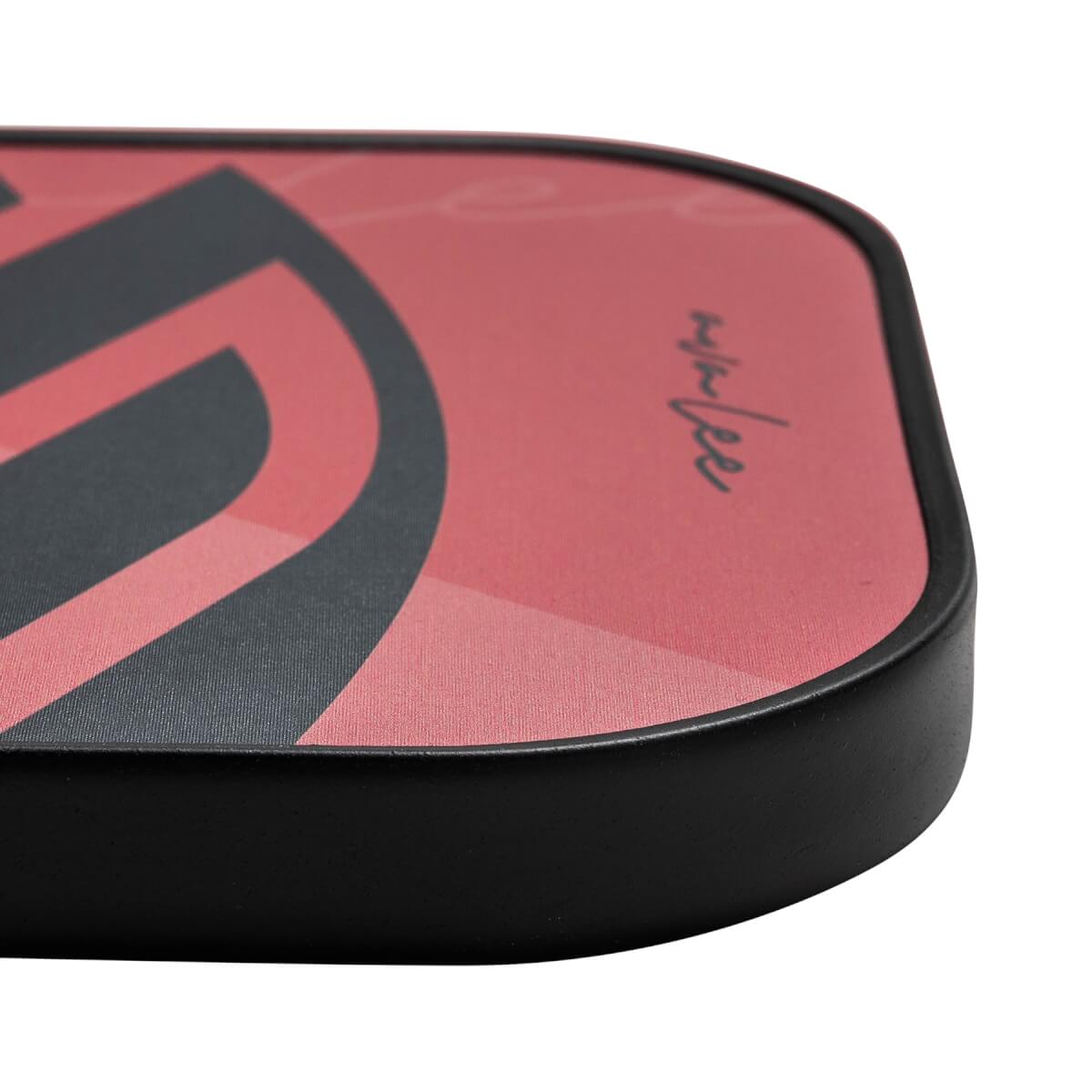 Corner view of a red pickleball paddle with black graphic design and AvaLee signature.