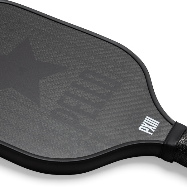Corner view of a black carbon fiber pickleball paddle with a star logo and PXIII text.
