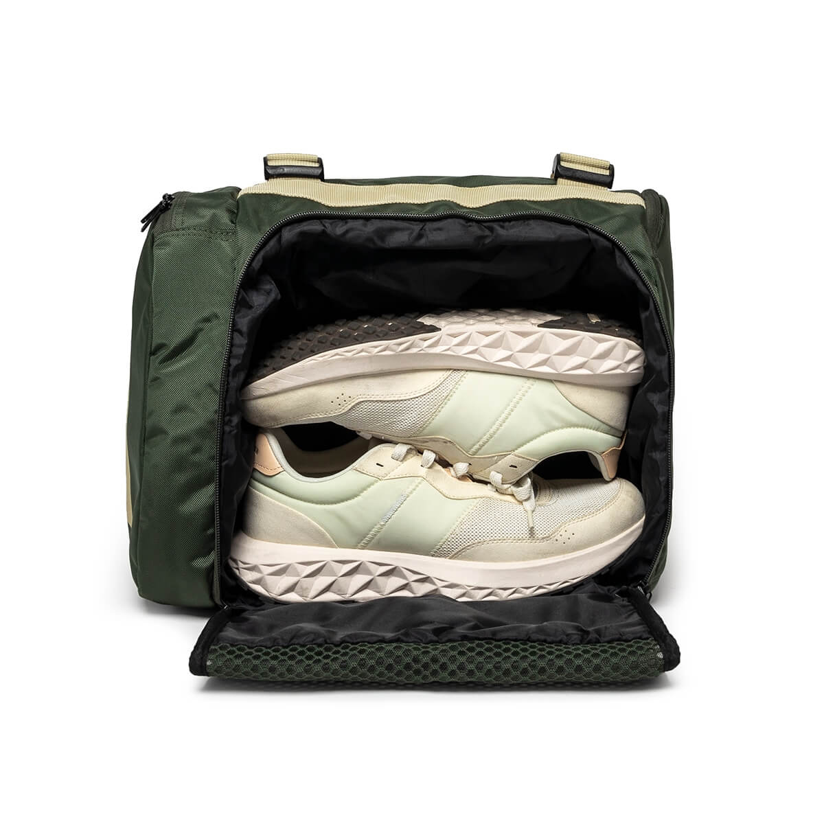 Front view of the open side compartment of a green duffel bag, showing a pair of light-colored sneakers neatly stacked inside.