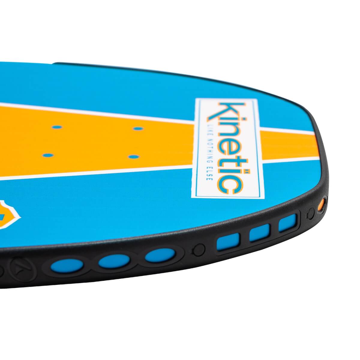 Corner view of a blue and orange pickleball paddle with Kinetic branding and a black perforated edge.