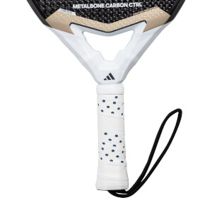 Close-up of a white padel racket grip with blue dots and a black wrist strap, showing METALBONE CARBON CTRL text.