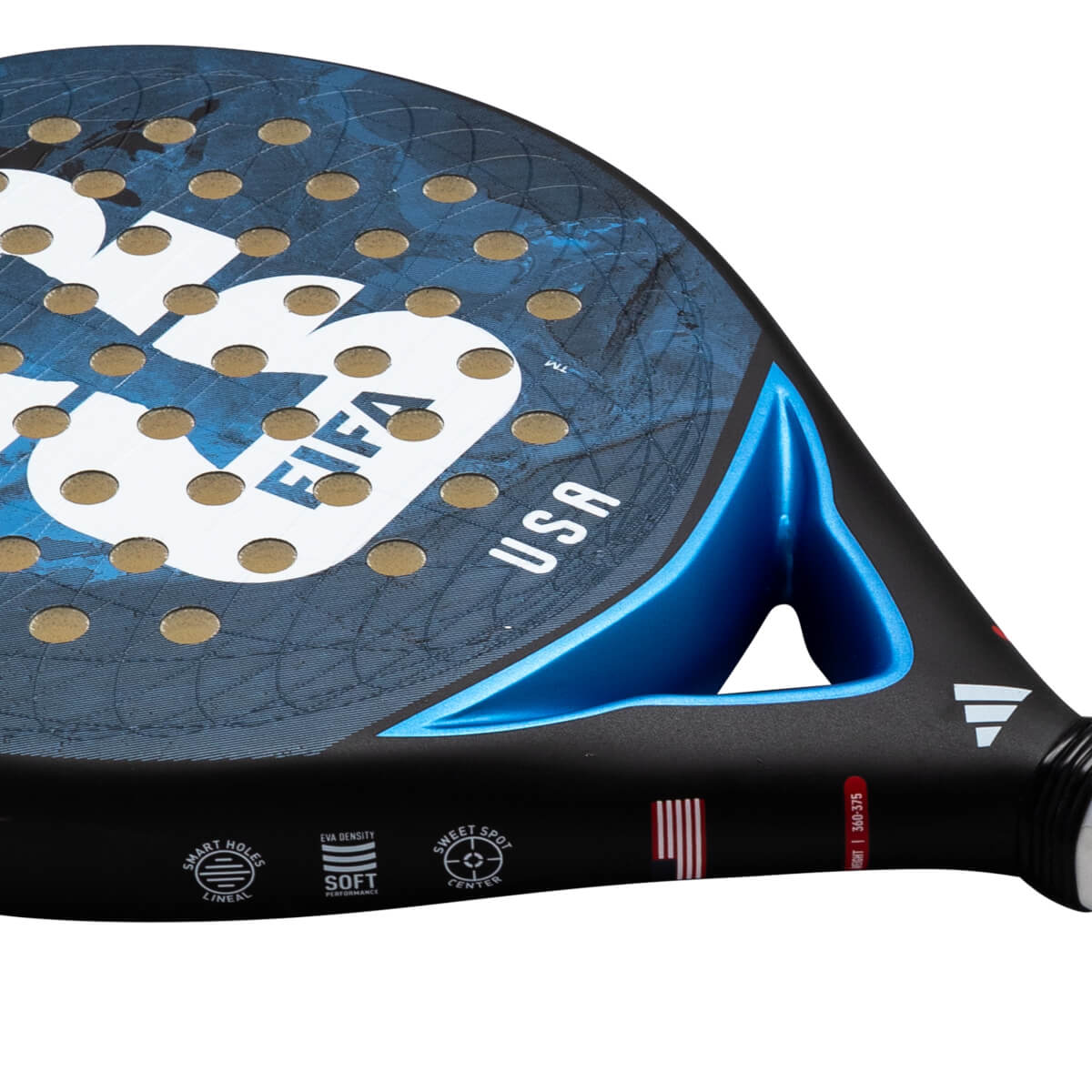 Angled close-up of a blue and black Adidas padel racket featuring gold-lined holes, a USA map graphic, and "USA" and "FIFA" text near a metallic blue bridge.