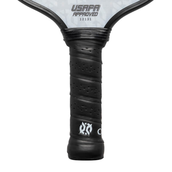 Close-up of a black pickleball paddle grip with perforated texture and white logo.