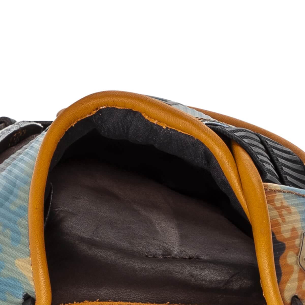 Close-up of the hand opening features orange leather piping, a dark padded interior, and a blue and tan camo shell on this Rawlings REV1X baseball glove.