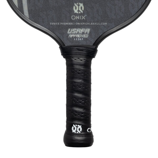 Close-up of a black pickleball paddle grip with perforated texture and USAPA approved stamp.