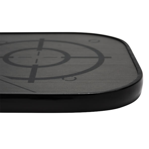 Corner view of a black pickleball paddle with a target graphic and textured surface.