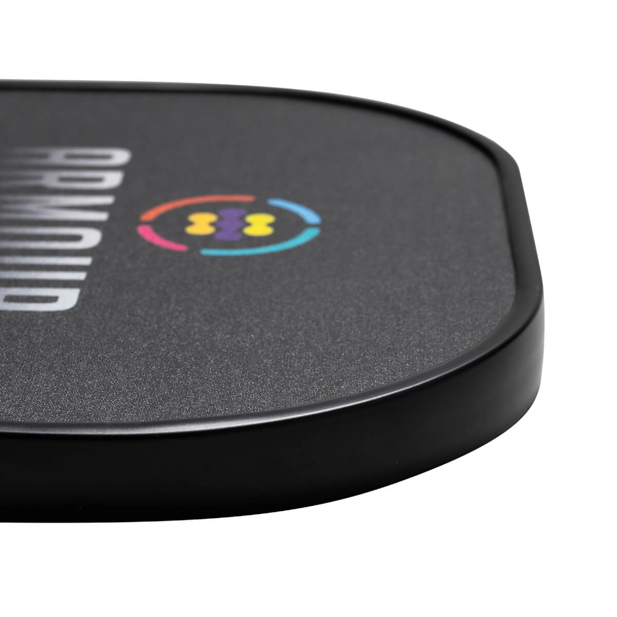Corner view of a black pickleball paddle with ARMOUR text and a colorful logo.