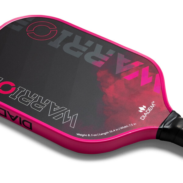 Corner view of a pink pickleball paddle with WARRIOR text and a pink smoke graphic.