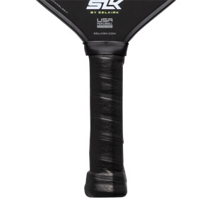 Close-up of a black pickleball paddle grip with perforations and the Selkirk logo.