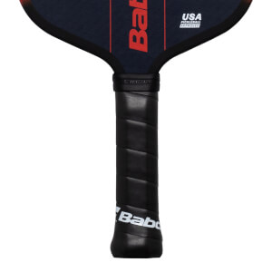 Close-up of a pickleball paddle handle showing the black grip with "Babolat" and "USA PICKLEBALL APPROVED" text.