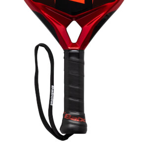Close-up of a red and black Babolat padel racket grip with a black wrist strap.