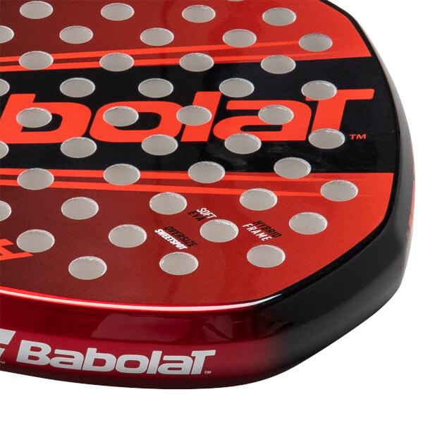 Close-up of a red and black Babolat padel racket face with silver holes, showing "SOFT EVA" and "HYBRID FRAME" text.