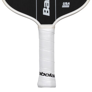 Close-up of a white pickleball paddle grip with "Babolat" and "USA PICKLEBALL APPROVED" text.