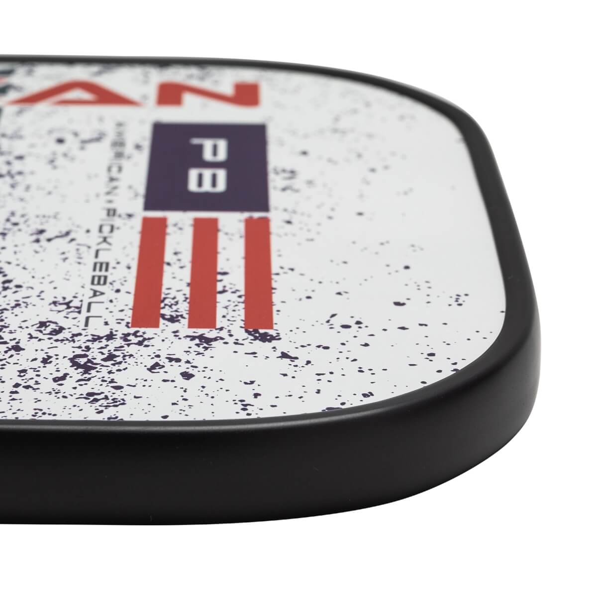 Corner view of a white pickleball paddle with red and blue PB logo and American flag design.
