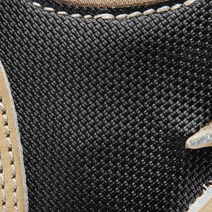 Close-up of a black baseball glove with tan leather trim and white stitching.