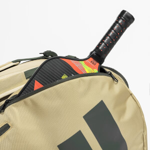 Close-up of a patterned pickleball paddle marked "USA PICKLEBALL APPROVED" and "SOFT" inside a zippered tan bag with large grey diagonal stripes.
