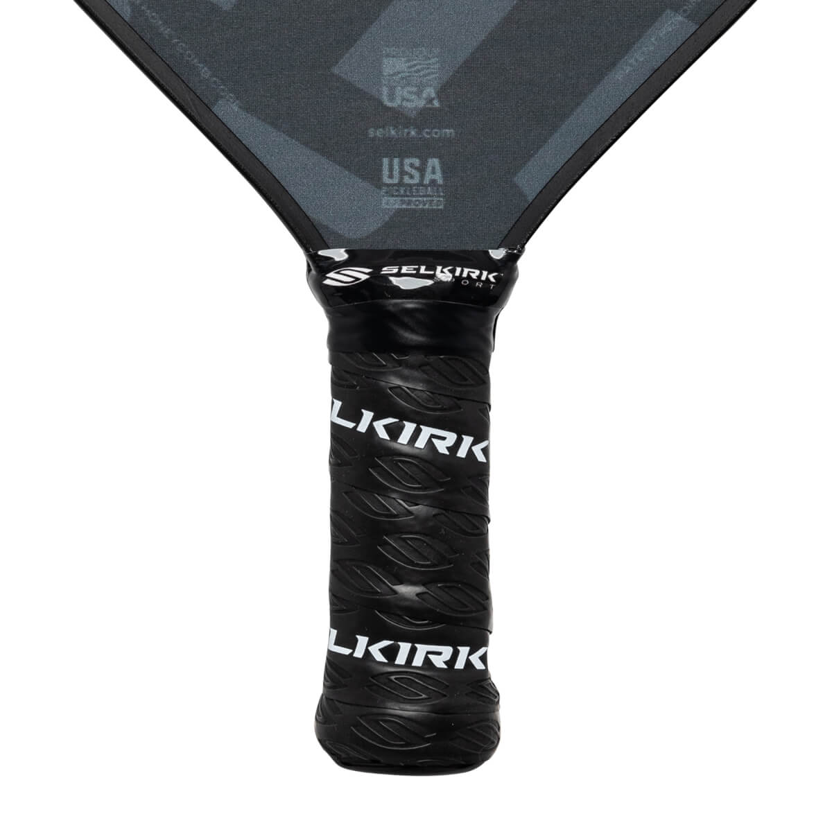 Close-up of a black pickleball paddle grip with Selkirk branding and leaf pattern.