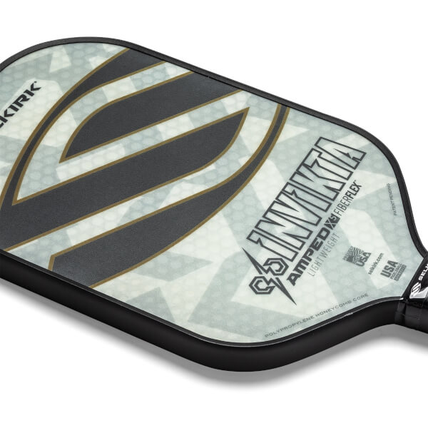 Corner view of a white pickleball paddle with black and gold accents, showing INVIKTA and AMPED text.