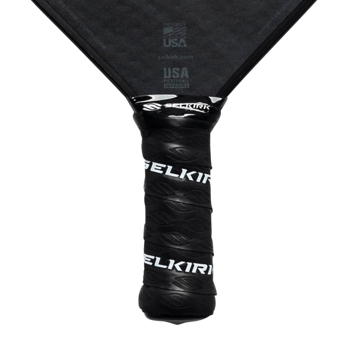 Close-up of a black pickleball paddle grip with white Selkirk branding.