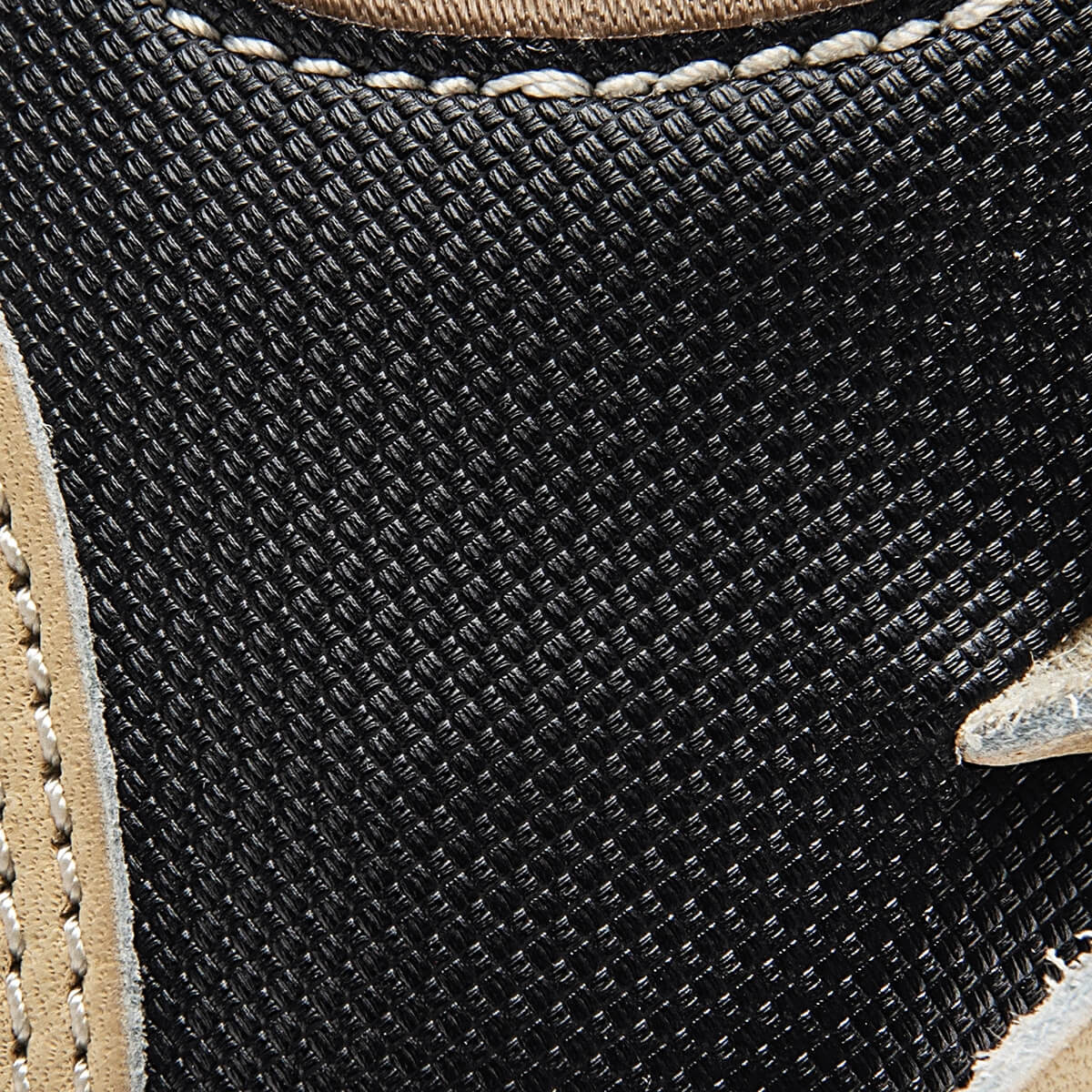 Close-up of a black baseball glove with tan leather trim and white stitching.