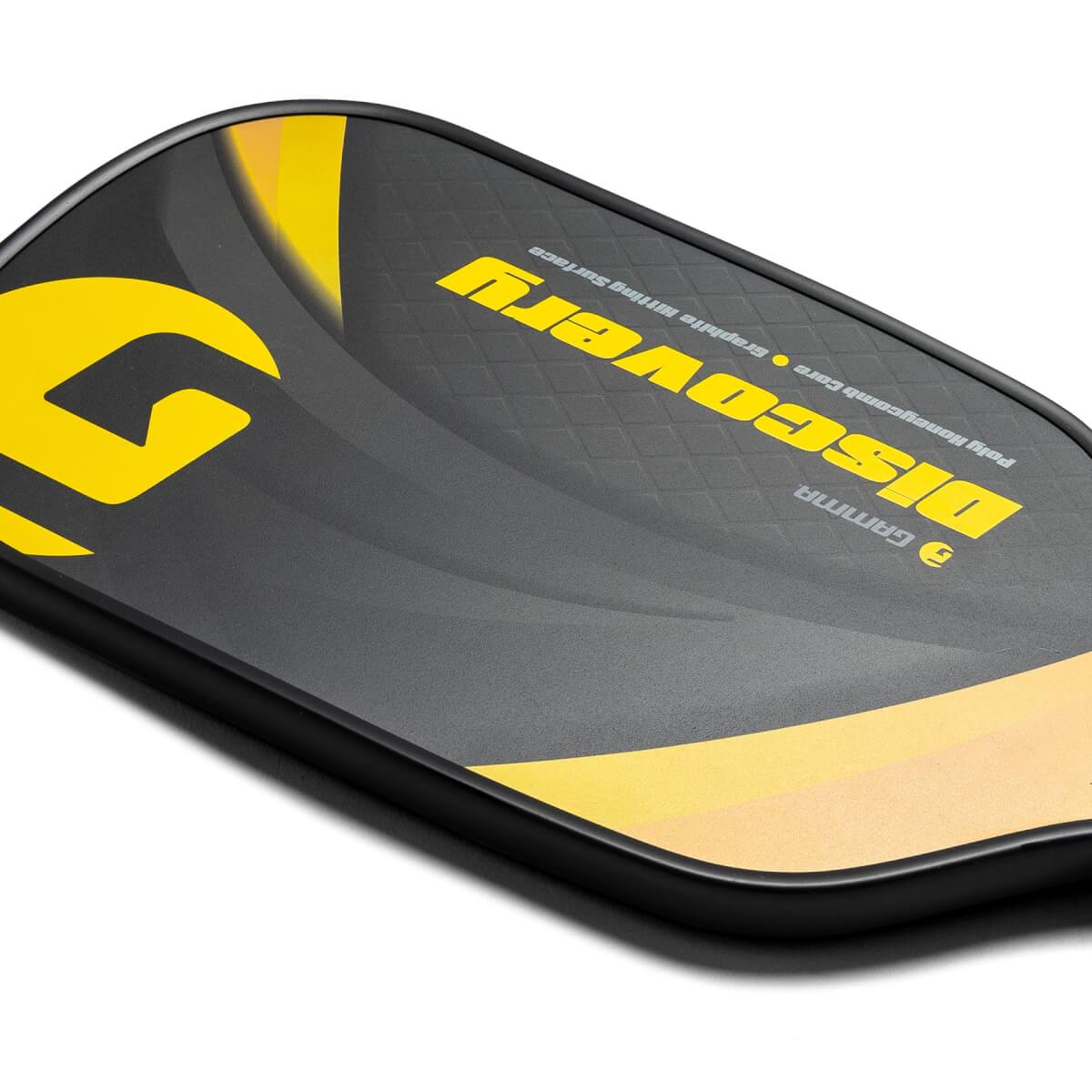 Corner view of a black GAMMA pickleball paddle with yellow Discovery text and a large yellow G graphic.