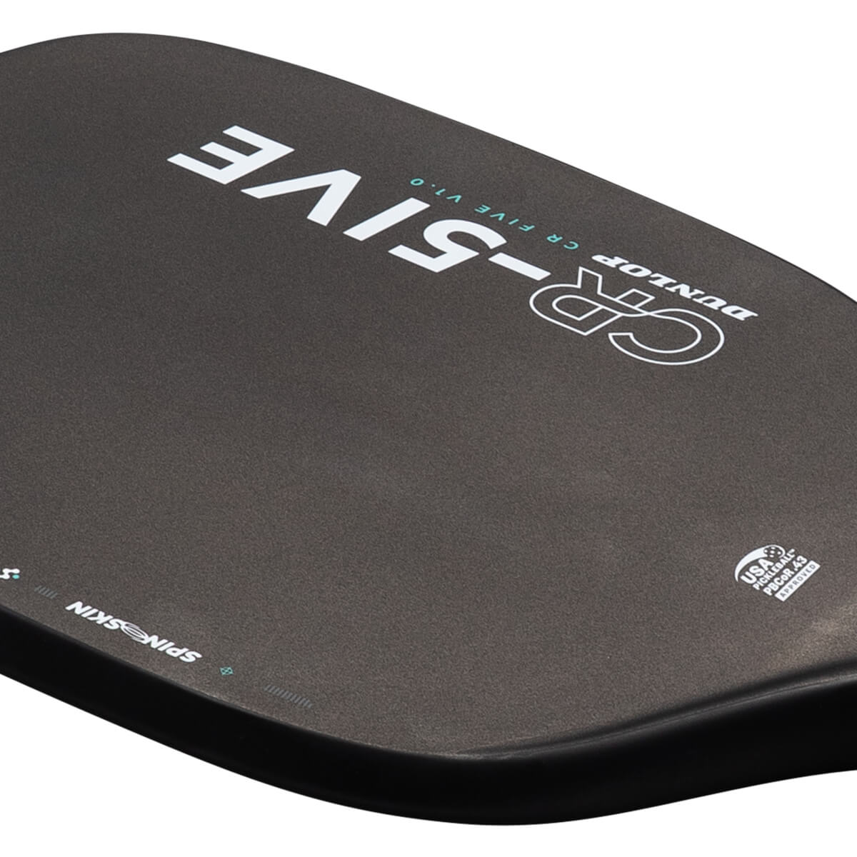Close-up view of the black paddle face featuring white and teal DUNLOP CR-FIVE V1.0 branding, SPIN SKIN along the edge, and the USA Pickleball logo.