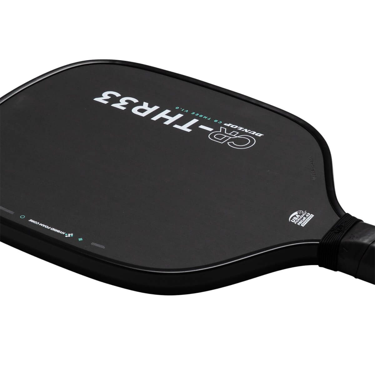 Angled close-up of a black pickleball paddle face featuring "CR-THR33" and "DUNLOP CR THREE V1.0" text alongside a "USA PICKLEBALL APPROVED" seal near the handle.