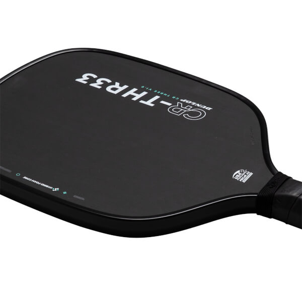 Angled close-up of a black pickleball paddle face featuring "CR-THR33" and "DUNLOP CR THREE V1.0" text alongside a "USA PICKLEBALL APPROVED" seal near the handle.