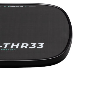 Close-up corner of the black paddle surface showing white "-THR33" text and a teal "HYBRID FOAM CORE" label along the rounded edge.