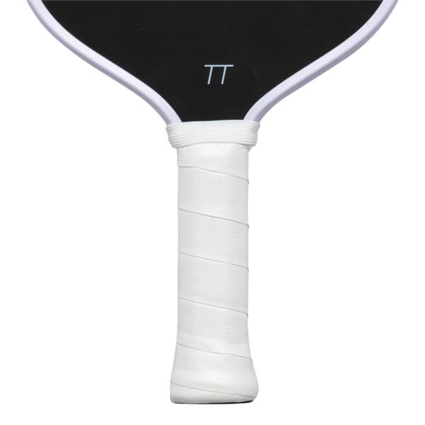 Close-up of the white wrapped handle with embossed "THE LOVE" text and the bottom of the black paddle face featuring a white "TT" logo.