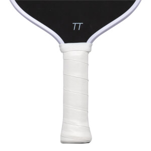 Close-up of the white wrapped handle with embossed "THE LOVE" text and the bottom of the black paddle face featuring a white "TT" logo.